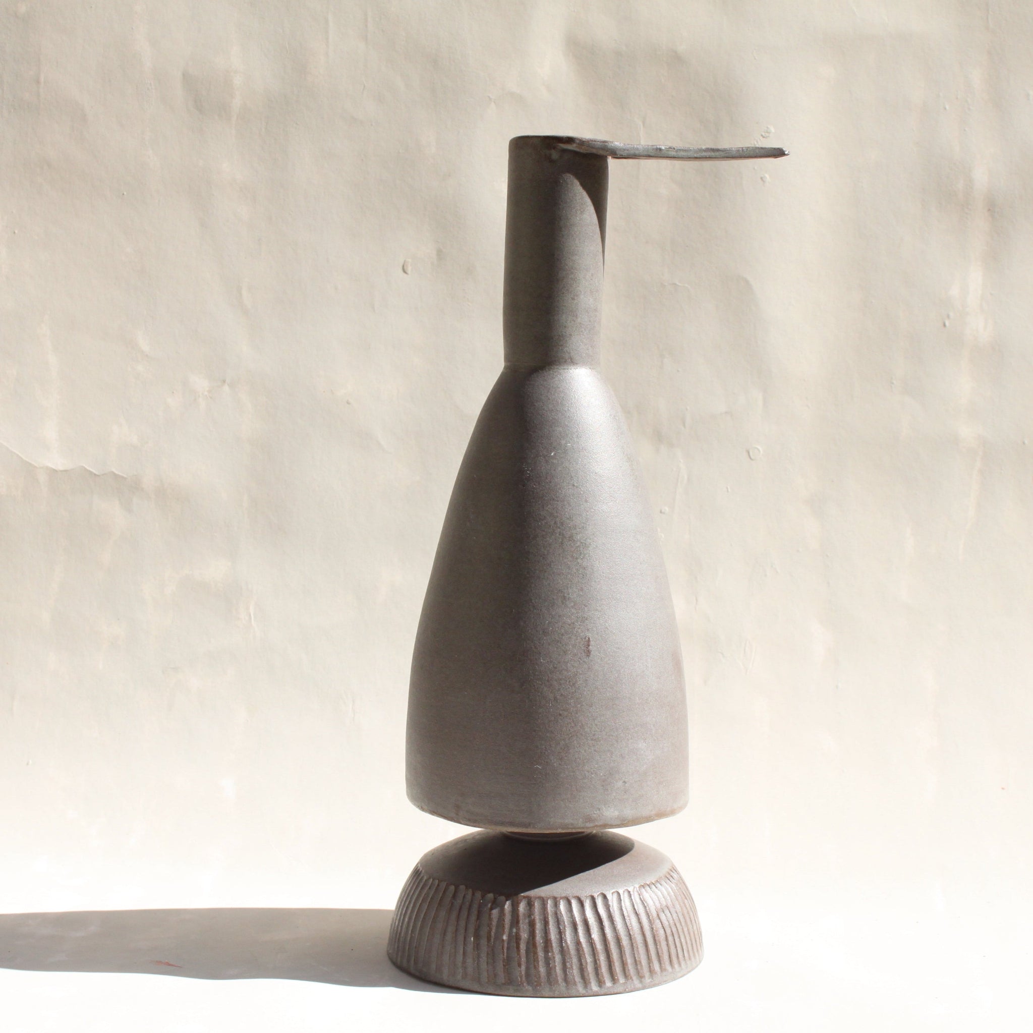 Eine Keramikkaraffe in Form eines stilisierten Reihers, mit einem abnehmbaren Schälchen als Fuss