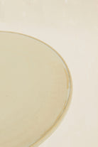 Detailansicht des modularen Pizzatellers aus der Kollektion ROSA MORADA von Martina Geroni in der Tonfarbe Fiore di Cotone, gefertigt aus Steingut, mit minimal erhöhtem Rand auf hellem Hintergrund.