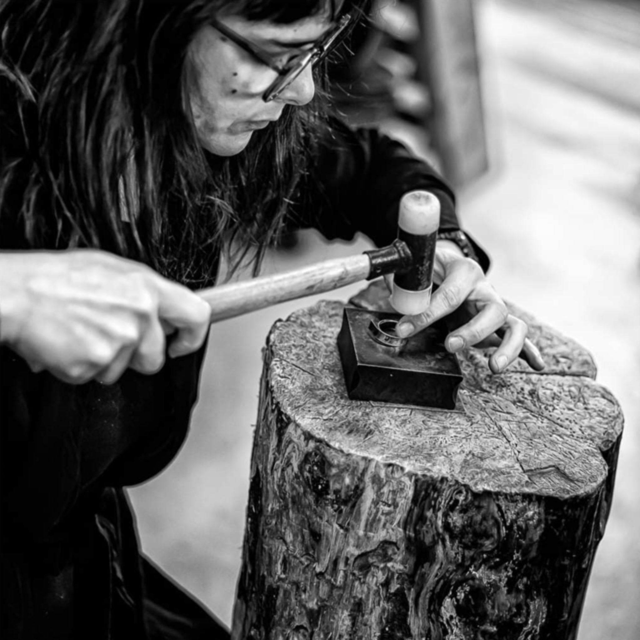 Annie Sibert, Gold- und Silberschmiedin und Schmuckdesignerin Annie Sibert sitzt mit einem Hammer und einem Ringdesign an einem kleinen Amboss in ihrem Atelier in Straßburg
