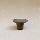 Modulare Untertasse aus der Kollektion ROSA MORADA von Martina Geroni in der Tonfarbe Buccia di Zenzero, einzeln gezeigt und auf den umgedrehten Espressobecher aufgesetzt, beide aus handgefertigtem Steingut.