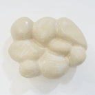 Keramische Wandskulptur in organischer, wolkenartiger Form; helle, leicht cremeweiße Oberfläche mit feinen Rissstrukturen und weicher, gewölbter Modellierung.