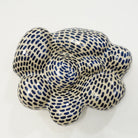 Keramische Wandskulptur mit organisch gewölbter, wolkenähnlicher Form; helles Grundmaterial, dicht überzogen mit gleichmäßig verteilten dunkelblauen Pinselstrichen. 